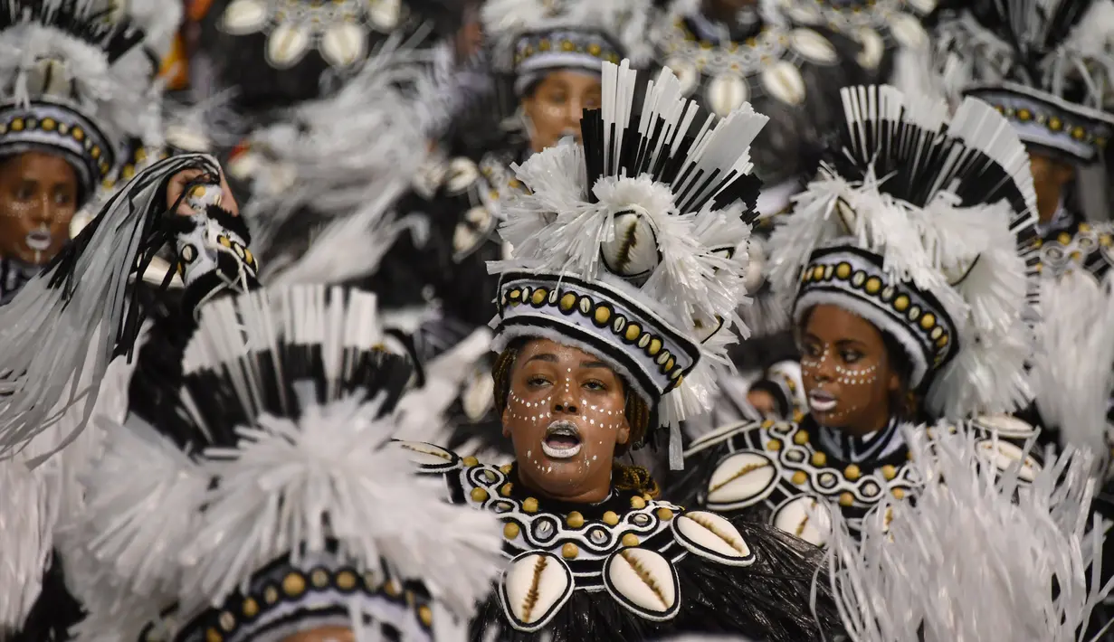 Sejumlah penari mengenakan kostum lengkap mengikuti parade karnaval di Sambadrome di Sao Paulo, Brasil (25/2). (AFP/Nelson Almeida)