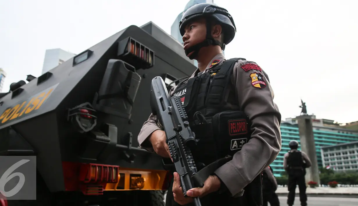 Anggota Brimob dengan senjata lengkap berjaga di sekitar Bundaran HI, Jakarta, Kamis (24/12). Polda Metro Jaya mengerahkan 8.978 personel untuk operasi lilin jaya 2015 dalam rangka pengamanan Natal 2015 dan tahun baru 2016. (Liputan6.com/Faizal Fanani)