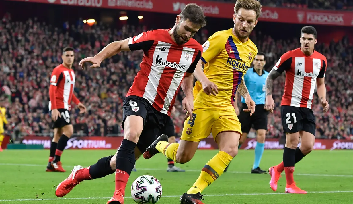 Pemain Athletic Bilbao, Yeray Alvarez berebut bola dengan gelandang Barcelona, Ivan Rakitic, pada babak perempat final Copa del Rey di San Mames, Kamis (6/2/2019). Barcelona kandas di babak perempat final Copa del Rey setelah takluk 0-1 di kandang Athletic Bilbao. (AP/Alvaro Barrientos)