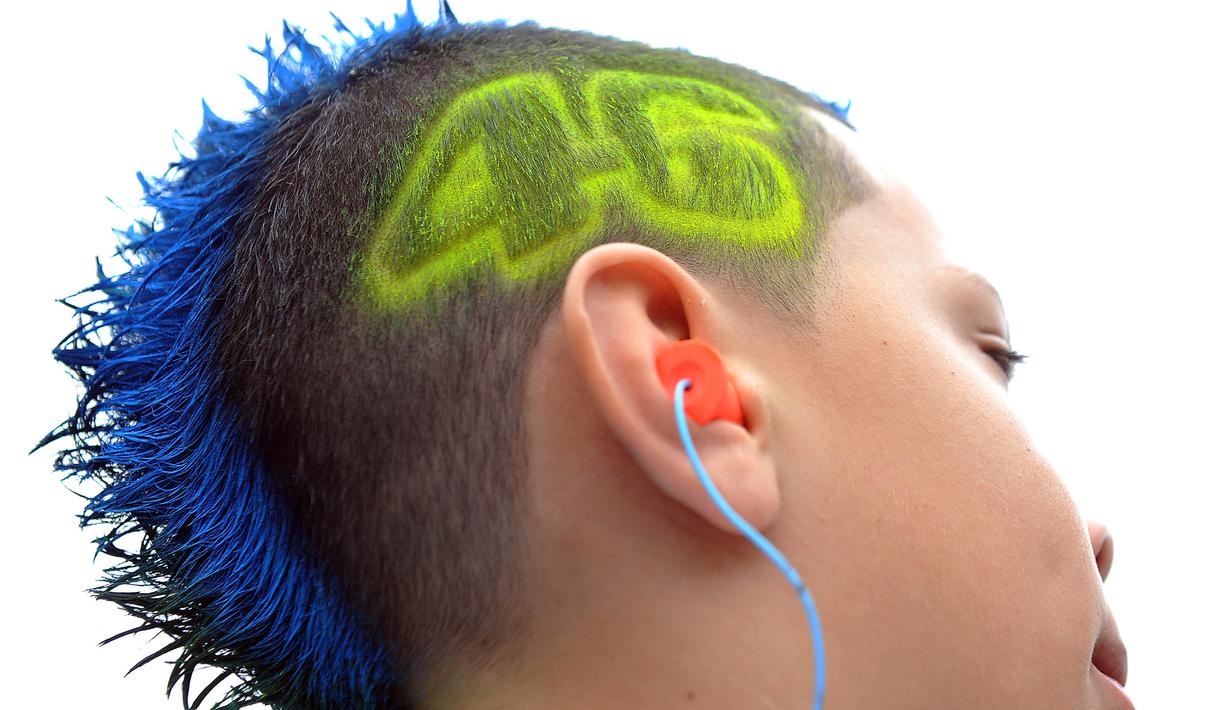 Seorang fans dari pebalap MotoGP, Valentino Rossi, mewarnai rambutnya dengan membentuk nomor motor dari sang idola saat GP USA di Sirkuit Laguna Seca, Amerika Serikat, Minggu (25/7/2010). (AFP/Gabriel Bouys)