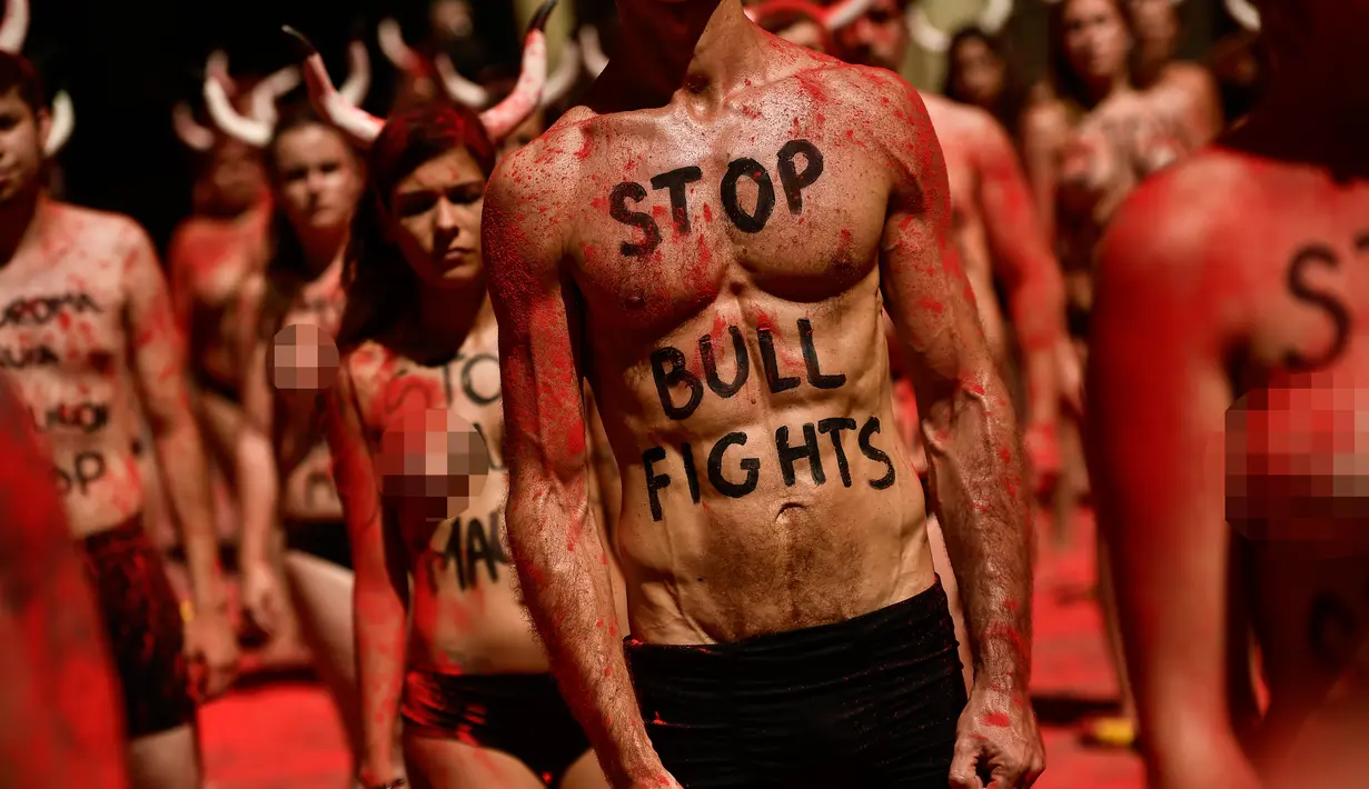 Sejumlah aktivis berunjuk rasa memprotes adu banteng dalam Festival San Fermin di depan Balai Kota di Pamplona, Spanyol utara, (5/7). Mereka menggelar aksi menutup tubuh mereka dengan debu merah. (AP Photo/Alvaro Barrientos)