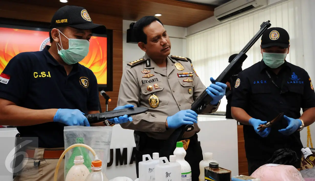 Kepala Biro Penmas Mabes Polri Kombes Pol Rikwanto (tengah) melihat barang bukti senapan angin terduga teroris di Jakarta, Jumat (25/11). Tim Densus 88 menahan satu orang terduga teroris berikut bahan racikan bom. (Liputan6.com/Helmi Fithriansyah)
