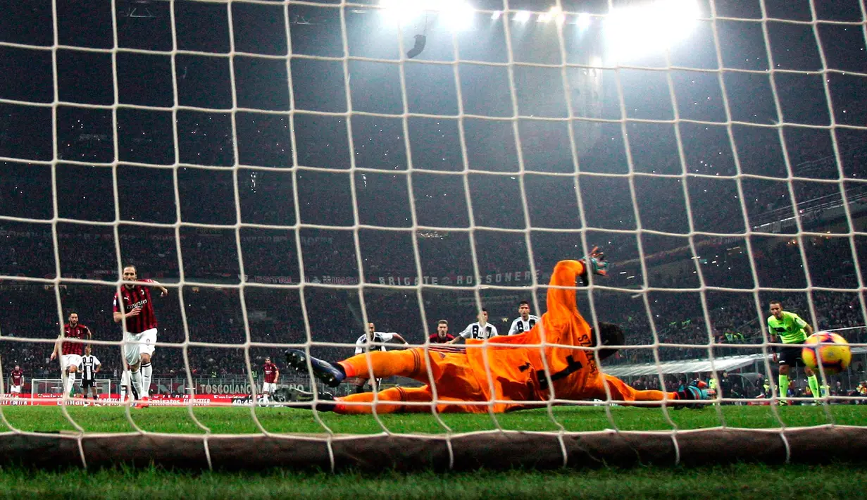 Kiper Juventus, Wojciech Szczesny berusaha menepis bola tendangan penalti striker AC Milan, Gonzalo Higuain saat bertanding pada lanjutan Liga Serie A Italia di stadion San Siro, Milan (11/11). Juventus menang 2-0 atas AC Milan. (AP Photo / Matteo Bazzi)