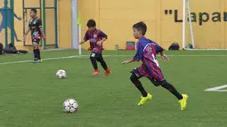 Anak-anak berusia 9 sampai 16 tahun ini tampak bersemangat berlatih di lapangan yang menggunakan rumput sintetis berstandar FIFA.