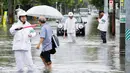 Petugas kepolisian mengatur jalan raya saat banjir merendam Saga, Jepang, Rabu (28/8/2019). Pejabat Badan Meteorologi Jepang, Yasushi Kajiwara memperingatkan warga yang tinggal di lokasi-lokasi rawan untuk segera angkat kaki tanpa menunggu peringatan lanjutan. (Takuto Kaneko/Kyodo News via AP)