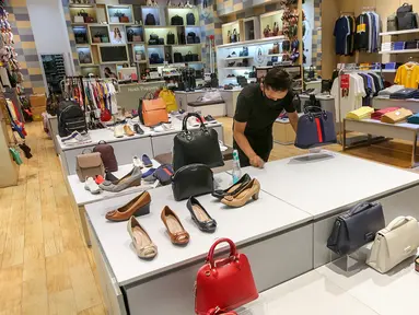 Karyawan tenant membersihkan meja display sepatu dan tas di Lippo Mall Puri, Jakarta, Rabu (3/6/2020). Menuju new normal Lippo Malls Indonesia (LMI) mendukung kebijakan Pemerintah dalam penerapan PSBB untuk mencegah penyebaran Covid-19. (Liputan6.com/Fery Pradolo)