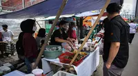 Pedagang melayani pembeli di Pasar Takjil Benhil, Jakarta, Selasa (13/4/2021). Pasar takjil yang ada setiap bulan Ramadhan tersebut dipadati warga untuk membeli makanan berbuka puasa. (Liputan6.com/Faizal Fanani)