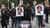 Aktivis hak-hak perempuan dengan poster memprotes pengetatan undang-undang aborsi ketat Polandia. (AP / Czarek Sokolowski)