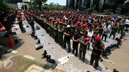 Massa dari Kokam Pemuda Muhammadiyah melaksanakan salat Jumat di depan gedung KPK, Jakarta, Jumat (24/3). Mereka berorasi menyampaikan 3 tuntutan dalam aksi #KawalKPKBerani, salah satunya menuntut penuntasan kasus korupsi e-KTP. (Liputan6.com/Johan Tallo)
