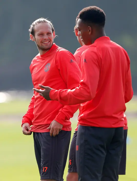 Gelandang MU, Daley Blind berbincang dengan penyerang Anthony Martial selama mengikuti latihan di Manchester United Training Ground, Inggris, (14/9).  Wayne Rooney dkk. akan melawat ke kandang Feyenoord, Jumat (16/9/2016) dinihari WIB. (Reuters/Ed Sykes)