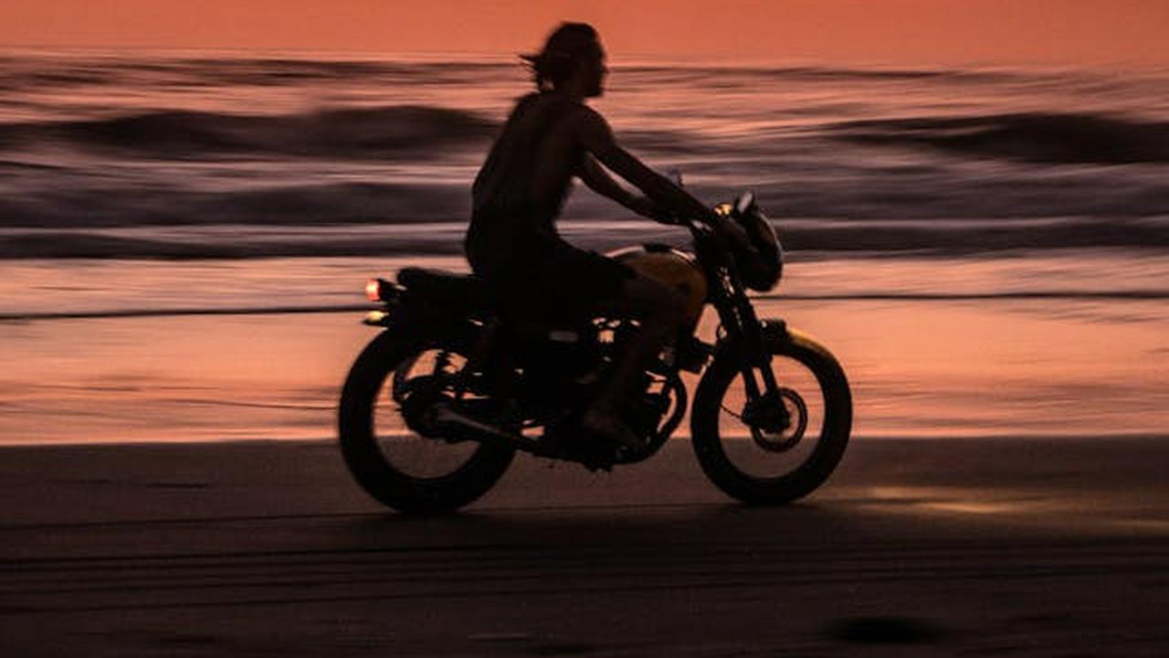 Ilustrasi Pria Mengendarai Motor di Pinggir Pantai