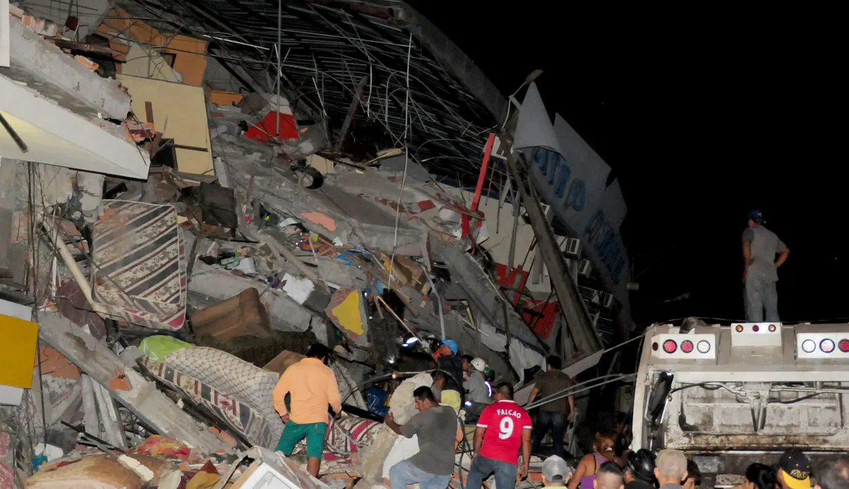  Sejumlah warga berdiri di reruntuhan bangunan untuk mencari korban pasca diguncang Gempa berkekuatan 7,8 SR, Kota Manta, Ekuador, Sabtu (16/4). Bencana tersebut menewaskan 28 orang dan diperkirakan akan bertambah. (REUTERS/Paul Ochoa)