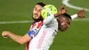 Penyerang Real Madrid, Vinicius Junior, duel udara dengan pemain Atletico Madrid, Koke, pada laga Liga Spanyol di Stadion Alfredo di Stefano, Minggu (13/12/2020). Real Madrid menang dengan skor 2-0. (AFP/Oscar Del Pozo)