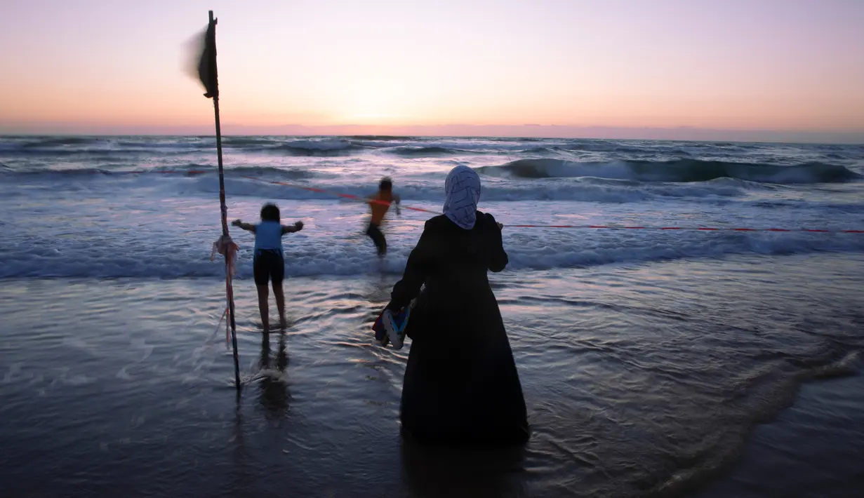 Orang Arab Israel menikmati laut Mediterania selama liburan Idul Fitri, di Tel Aviv, Israel (25/5/2020). Idul Fitri menandai akhir bulan suci Ramadhan, perayaan tiga hari yang biasanya menggembirakan telah berkurang secara signifikan karena pandemi coronavirus.  (AP Photo/Oded Balilty)