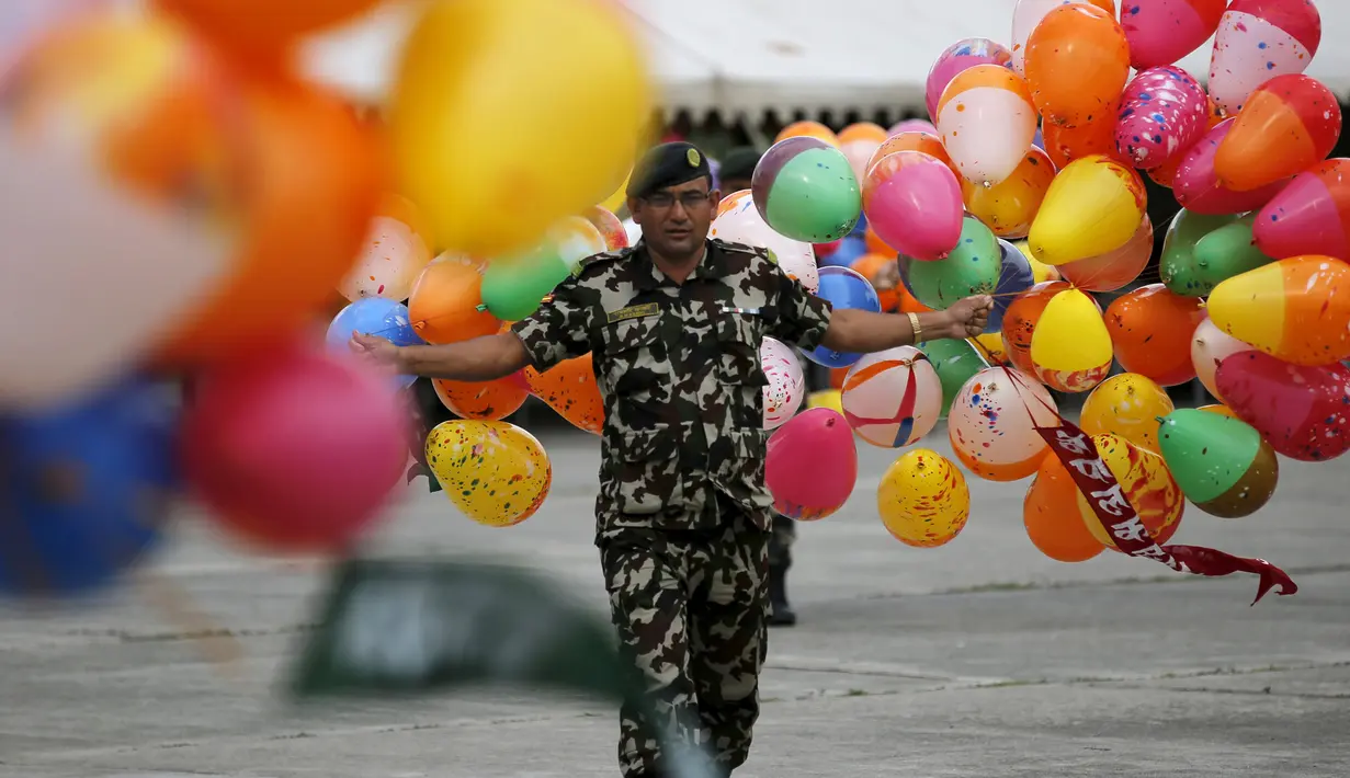 Seorang tentara memegang balon di depan gedung parlemen jelang Presiden Ram Baran Yadav resmi mengesahkan konstitusi baru di Kathmandu, Nepal, Minggu (20/9/2015). Nepal akan mengadopsi piagam demokratis secara penuh. (REUTERS/Navesh Chitrakar)