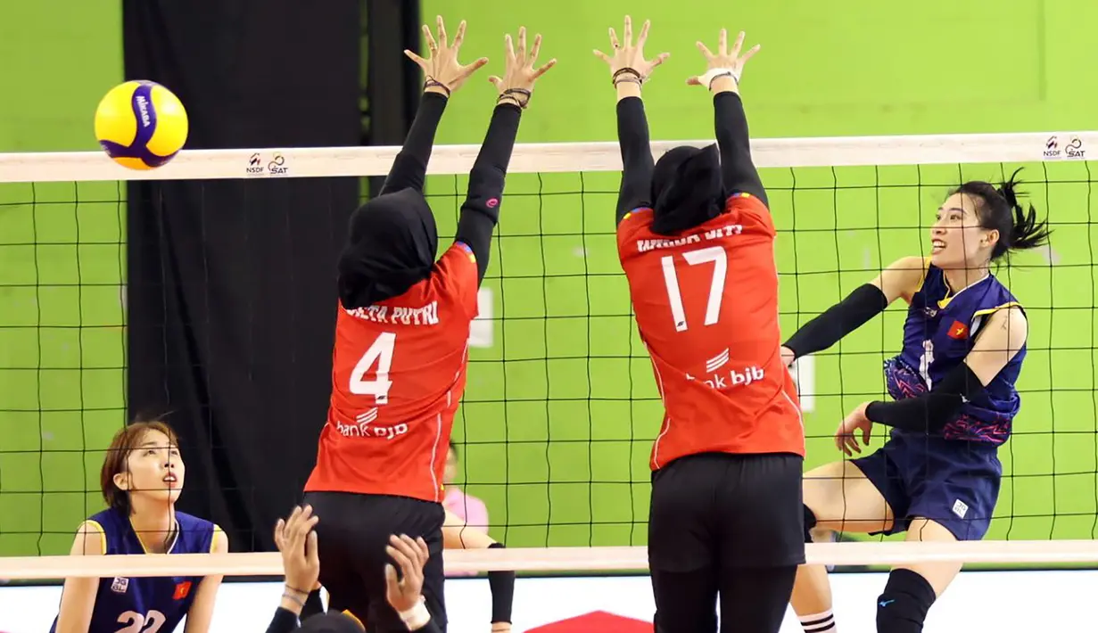 Pemain Timnas voli putri Vietnam, Pham Thi Nguyet Anh melepaskan spike yang berusaha diblok dua pemian Indonesia, Wilda Siti Nurfadhilah (kanan) dan Arneta Putri Amelian pada laga pertama putaran kedua SEA V League 2023 di Chiang Mai, Thailand, Jumat (11/8/2023). Vietnam menang 3-0 (25-19, 25-22, 25-10) atas Indonesia. (Dok. avcvolley)