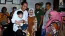 Presiden Jokowi beserta Ibu Iriana dan Jan Ethes menyapa warga saat makan soto bersama keluarganya di Solo, Jawa Tengah, Jumat (30/3). Kedai soto ini sudah menjadi langganan Jokowi sejak masih menjadi Wali Kota Solo. (Liputan6.com/Pool/Biro Pers Setpres)