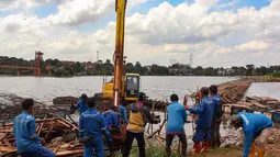 Pembongkaran dilakukan untuk mengembalikan fungsi Setu Tujuh Muara ke kondisi alaminya. Tampak dalam foto, petugas Dinas Sumber Daya Air Pemerintah Provinsi Jawa Barat membongkar tiang pancang beton yang dipasang di Setu Tujuh Muara, Sawangan, Depok, Senin (16/01/2026). (Merdeka.com/Arie Basuki)