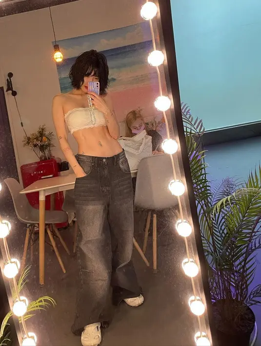Di potret lainnya, HyunA tidak ragu pamer rata dengan outfit minimalis. Ia melakukan mirror selfie dengan strapless top bertekstur dan baggy jeans. [instagram/hyunah_aa]