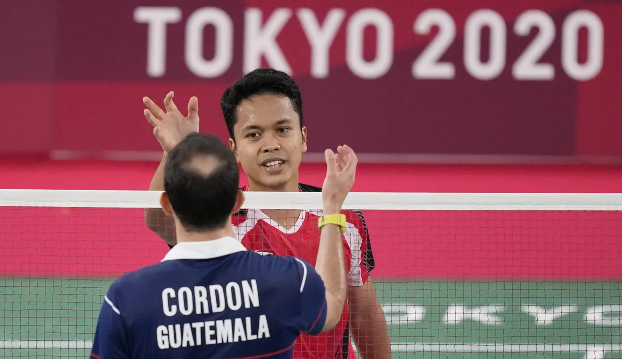Pebulu tangkis Indonesia Anthony Sinisuka Ginting berjabat tangan dengan Kevin Cordon dari Guatemala usai perebutan medali perunggu badminton tunggal putra Olimpiade Tokyo 2020 di Musashino Forest Sports Plaza, Senin (2/8/2021). Anthony Ginting menang 21-11 dan 21-13. (AP/Dita Alangkara)