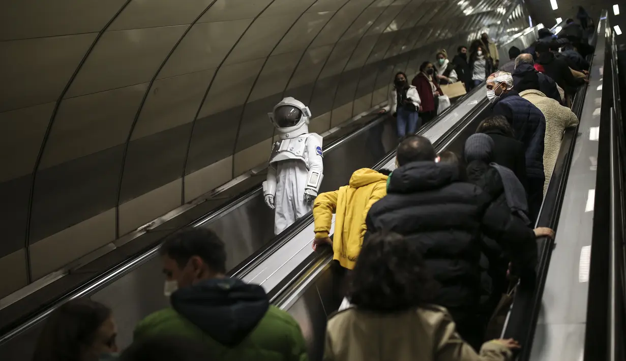 Seorang pria berpakaian astronot menaiki eskalator di stasiun metro sebagai bagian dari kampanye untuk mempromosikan Pameran Luar Angkasa NASA di Istanbul, Turki, pada 4 Desember 2021. Pameran tersebut akan dibuka untuk umum bulan ini. (AP Photo/Emrah Gurel)