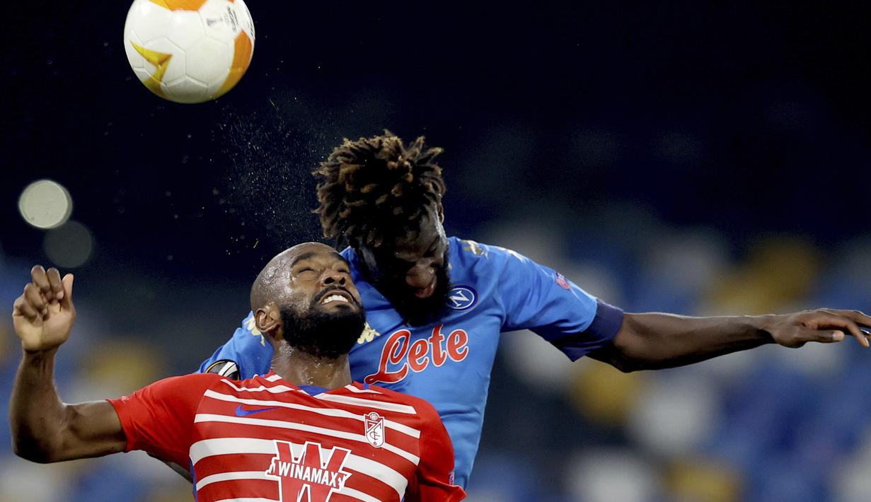 Gelandang Napoli, Tiemoue Bakayoko (atas) berduel udara dengan gelandang Granada, Yangel Herrera dalam laga leg kedua babak 32 Besar Liga Europa 2020/21 di Diego Armando Maradona Stadium, Kamis (25/2/2021). Napoli menang 2-1 atas Granada. (LaPresse via AP/Alessandro Garofalo)