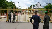 Petugas kepolisian Kamboja berjaga di depan gerbang yang ditutup di pos pemeriksaan perbatasan internasional Poipet, yang menghubungkan Kamboja dan Thailand, di Provinsi Banteay Meanchey, pada 24 Juni 2025. (Dok.&nbsp;AFP)&nbsp;