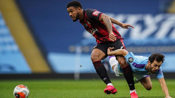 Gelandang Manchester City, Bernardo Silva berusaha merebut bola yang dibawa pemain Bournemouth, Joshua King pada pertandingan lanjutan Liga Inggris di Stadion Ethiopia di Manchester, Inggris (15/7/2020). Manchester City menang tipis 2-1 atas Bournemouth. (AP photo/Dave Thompson, Pool)
