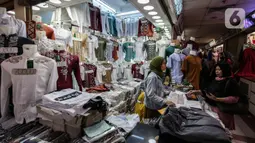 Pedagang melayani pembeli di Pasar Tanah Abang, Jakarta, Selasa (6/4/2021). Menjelang bulan Ramadan, Pasar Tanah Abang mulai dipadati pengunjung untuk berbelanja busana, namun menurut pedagang jumlah pengunjung bulan Ramadan kali ini tidak seramai sebelum pandemi Covid-19. (Liputan6.com/Johan Tallo)