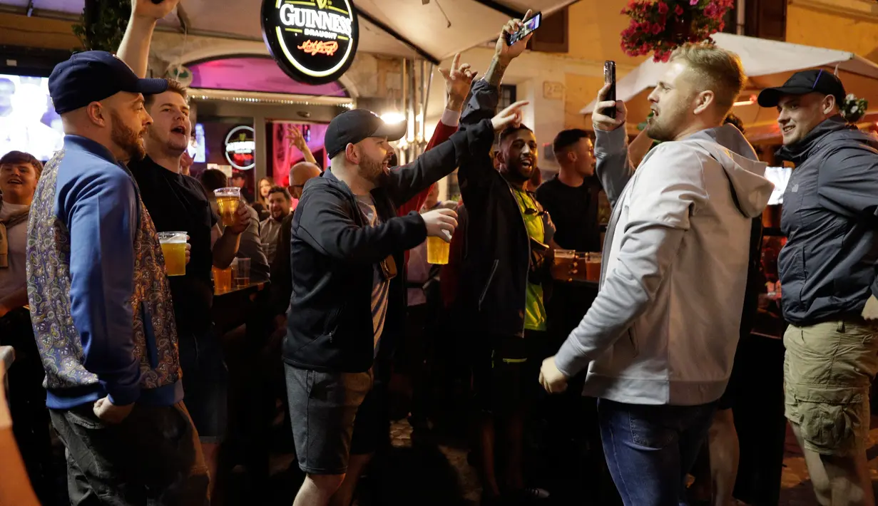Pendukung Liverpool bernyanyi dan mendukung tim mereka di sebuah pub di alun-alun Campo de 'Fiori Roma, Italia (1/5). Liverpool akan menghadapi AS Roma di leg kedua semifinal Liga Champions. (AP Photo/Andrew Medichini )