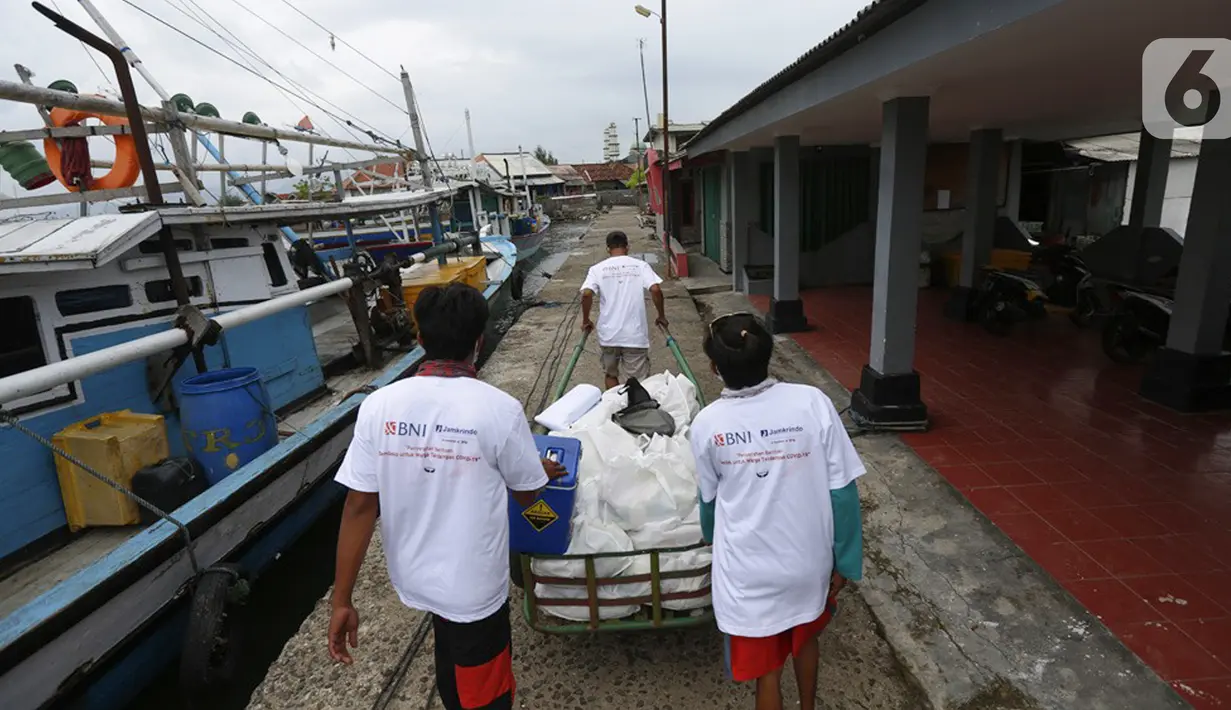 Jurnalis membawa gerobak berisi bantuan sembako di Pulau Panjang, Serang, Banten, Sabtu (30/1/2021). Kegiatan Jurnalis Peduli yang bekerjasama dengan BNI dan Jamkrindo bertujuan meringankan beban warga terdampak Covid-19 yang memiliki mata pencarian sebagai nelayan. (Liputan6.com/Pool/JP)