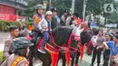 Seorang anak menaiki kuda dari Detasemen Turangga Direktorat Polisi Satwa Polri saat Car Free Day (CFD) atau Hari Bebas Kendaraan Bermotor di kawasan Bundaran HI, Jakarta, Minggu (19/2/2023).Polisi berkuda selain ditugaskan untuk pengamanan simpatik juga untuk menghibur warga dan anak-anak saat Hari Bebas Kendaraan Bermotor serta memperkenalkan profesi tersebut kepada warga. (Lipitan6.com/Angga Yuniar)
