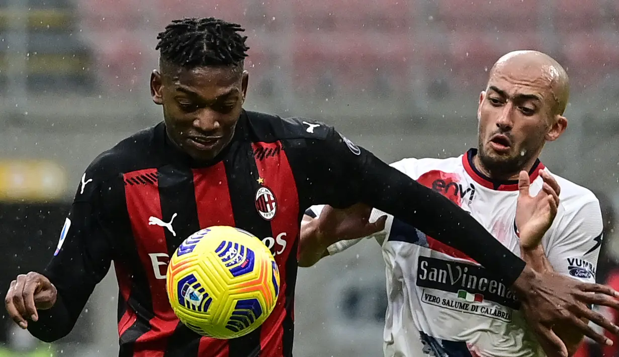 Striker AC Milan, Rafael Leao (kiri) berebut bola dengan gelandang Crotone, Ahmed Benali dalam laga lanjutan Liga Italia 2020/21 pekan ke-21 di San Siro Stadium, Milan, Minggu (7/2/2021). AC Milan menang 4-0 atas Crotone. (AFP/Miguel Medina)