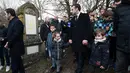 Presiden Prancis Emmanuel Macron berjalan melewati makam Yahudi yang dicoret simbol Nazi di pemakaman Yahudi, Quatzenheim, Prancis, Selasa (19/2). Macron menyempatkan diri untuk memeriksa kerusakan yang ditimbulkan. (Frederick FLORIN/AFP)