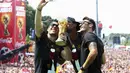 Lukas Podolski, Jerome Boateng dan Mesut Oezil ([dari kiri ke kanan) ber"selfie" ria di atas panggug perayaaan kemenangan Timnas Jerman, Berlin, (15/7/2014). (REUTERS/Alex Grimm/Pool)