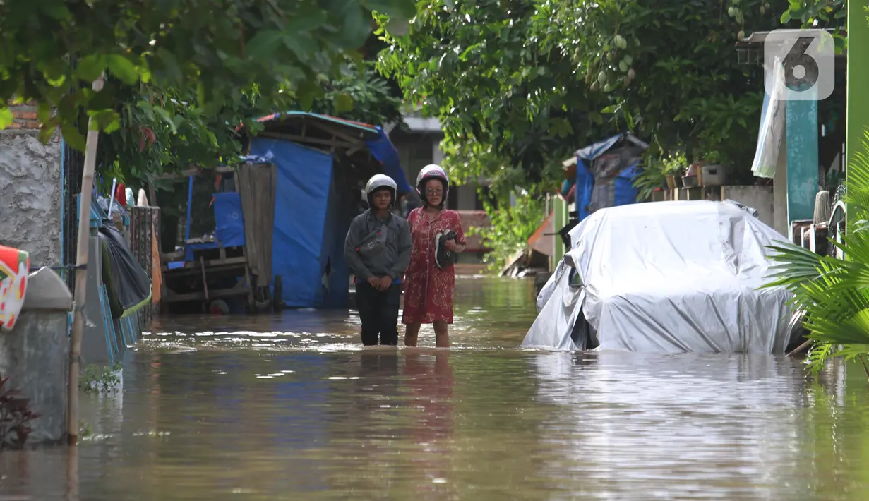 Aktivitas warga saat banjir di Desa Sukajaya, Serang, Banten, Rabu (2/3/2022). Banjir yang melanda kawasan Masjid Banten Lama setelah curah hujan tinggi mengguyur Kota Serang beberapa hari lalu mengakibatkan Kali Cibanten meluap dan menggenangi 22 titik. (merdeka.com/Imam Buhori)