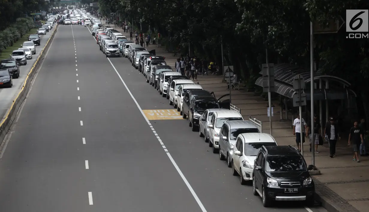 Ratusan mobil sopir taksi online terparkir di Jalan Medan Merdeka Barat, Jakarta, Rabu (14/2). Mereka menolak Permenhub Nomor 108 Tentang Penyelenggaraan Angkutan Orang Dengan Kendaraan Bermotor Umum Tidak Dalam Trayek. (Liputan6.com/Arya Manggala)