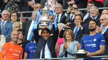Pelatih Chelsea, Antonio Conte mengangkat trofi Piala FA usai pertandingan melawan Manchester United pada babak final Piala FA di stadion Wembley di London (19/5). Chelsea mengalahkan MU 1-0. (AP Photo / Tim Ireland)
