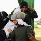 Sejumlah anggota polisi Syariah membantu seorang wanita setelah dia dicambuk di depan umum di Lhokseumawe, Aceh, Senin (28/6/2021). Wanita yang didakwa telah melakukan hubungan seks pranikah itu dihukum dengan 100 cambukan. (Azwar Ipank/AFP)