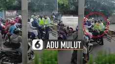 Pengemudi motor terlihat sedang adu mulut dengan petugas ketika ingin memasuki jalur busway.