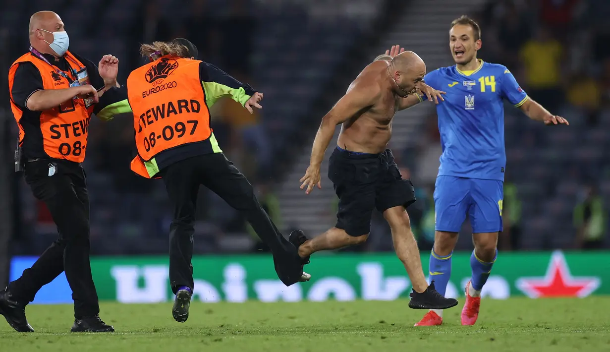 Seorang penyusup masuk ke lapangan setelah Ukraina mencetak gol kedua mereka selama pertandingan sepak bola babak 16 besar UEFA EURO 2020 antara Swedia melawan Ukraina yang berlangsung di Hampden Park, Glasgow pada 29 Juni 2021. (AFP/Pool/Lee Smith)