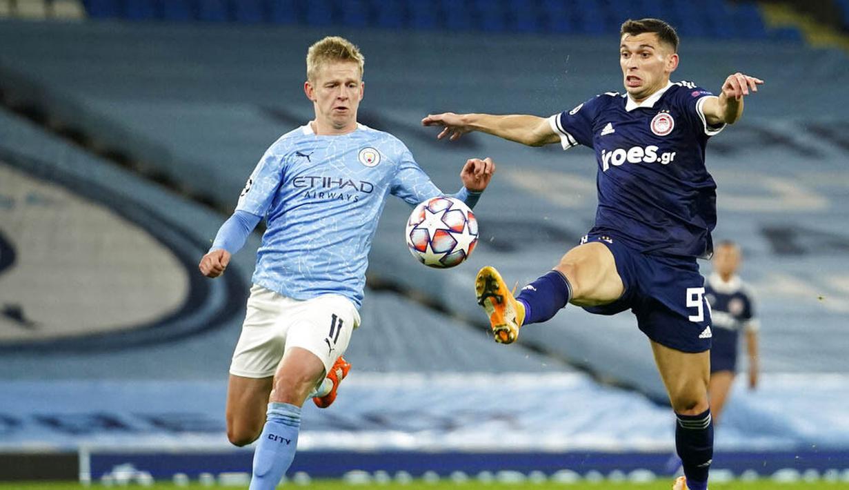 Pemain Manchester City, Oleksandr Zinchenko, berebut bola dengan pemain Olympiakos, Lazar Randelovic, pada laga Liga Champions di Stadion Etihad, Rabu (4/11/2020). Manchester City menang dengan skor 3-0. (AP/Dave Thompson)