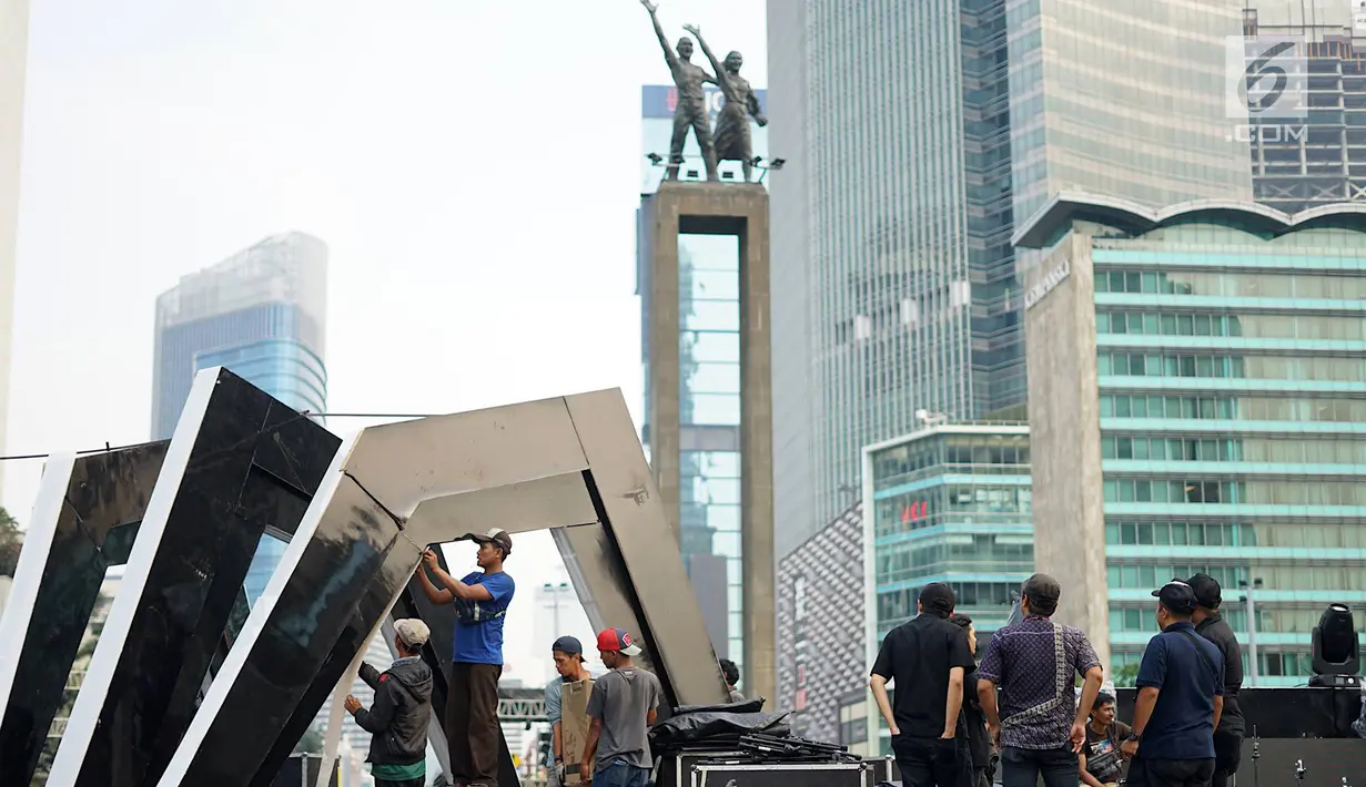 Pekerja menyelesaikan pembuatan panggung hiburan malam puncak HUT Ke-492 Kota Jakarta di Bundaran HI, Jakarta, Jumat (21/6/2019).Rangkaian malam puncak HUT Jakarta diisi dengan live mural, bazar kreatif dan donasi, video mapping hingga festival musik. (Liputan6.com/Immanuel Antonius)