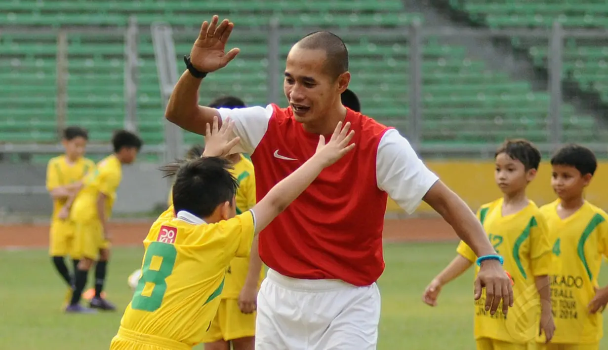 Salah satu anak terlihat bersorak dan berusaha memeluk Kurniawan Dwi Yulianto usai memasukkan bola saat berlatih di Stadion GBK Jakarta, (6/6/2014). (Liputan6.com/Helmi Fithriansyah)
