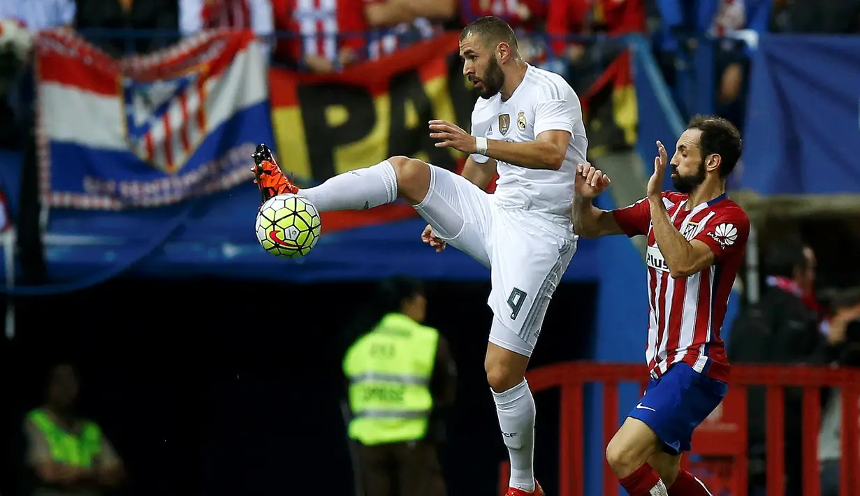 Pemain Real Madrid Karim Benzema (kiri) berebut bola dengan Pemain Atletico Madrid Juanfran Torres dalam lanjutan liga Spanyol di Vicente Calderon stadium in Madrid, Senin (05/10/2015). Atletico vs Madrid seri 1-1.(REUTERS/Sergio Perez)