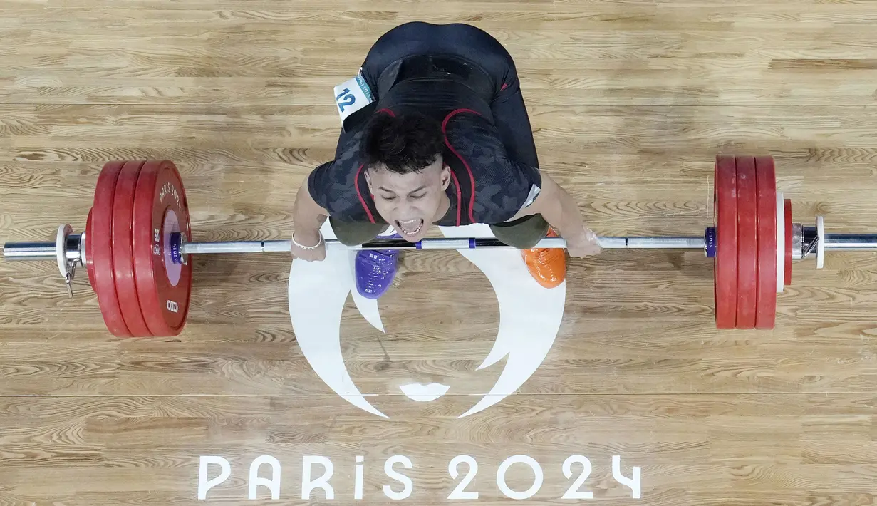 Rizki mengakhiri penantian panjang tim angkat besi untuk mempersembahkan medali emas di Olimpiade. (AP Photo/Dita Alangkara,Pool)