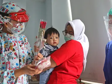 Dokter anak J. Mila Hardiani memberikan bunga dan kue ke pasien di Rumah Sakit Ibu dan Anak Tambak, Jakarta, Selasa (22/12/2020). Pemberian bunga dan kue kepada pasien rawat inap dan pasien yang kontrol dilakukan untuk memperingati perayaan Hari Ibu. (Liputan6.com/Herman Zakharia)