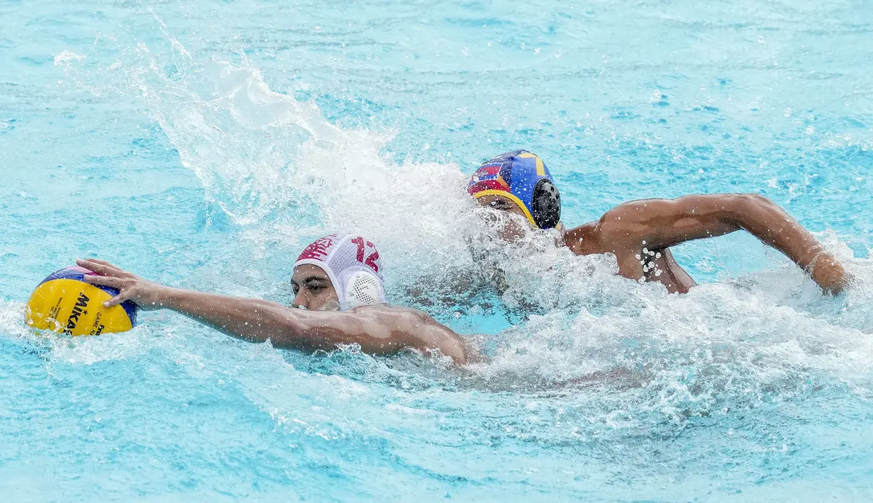 Pemain Tim Polo Air Indonesia, Zenal Arifin (kiri) berebut bola dengan pemain Tim Polo Air Kamboja, Chhiom Saki pada nomor polo air putra SEA Games 2023 di Phnom Penh, Kamboja, Jumat (13/05/2023). Indonesia menang telak dengan skor 37-2. (AP Photo/Tatan Syuflana)