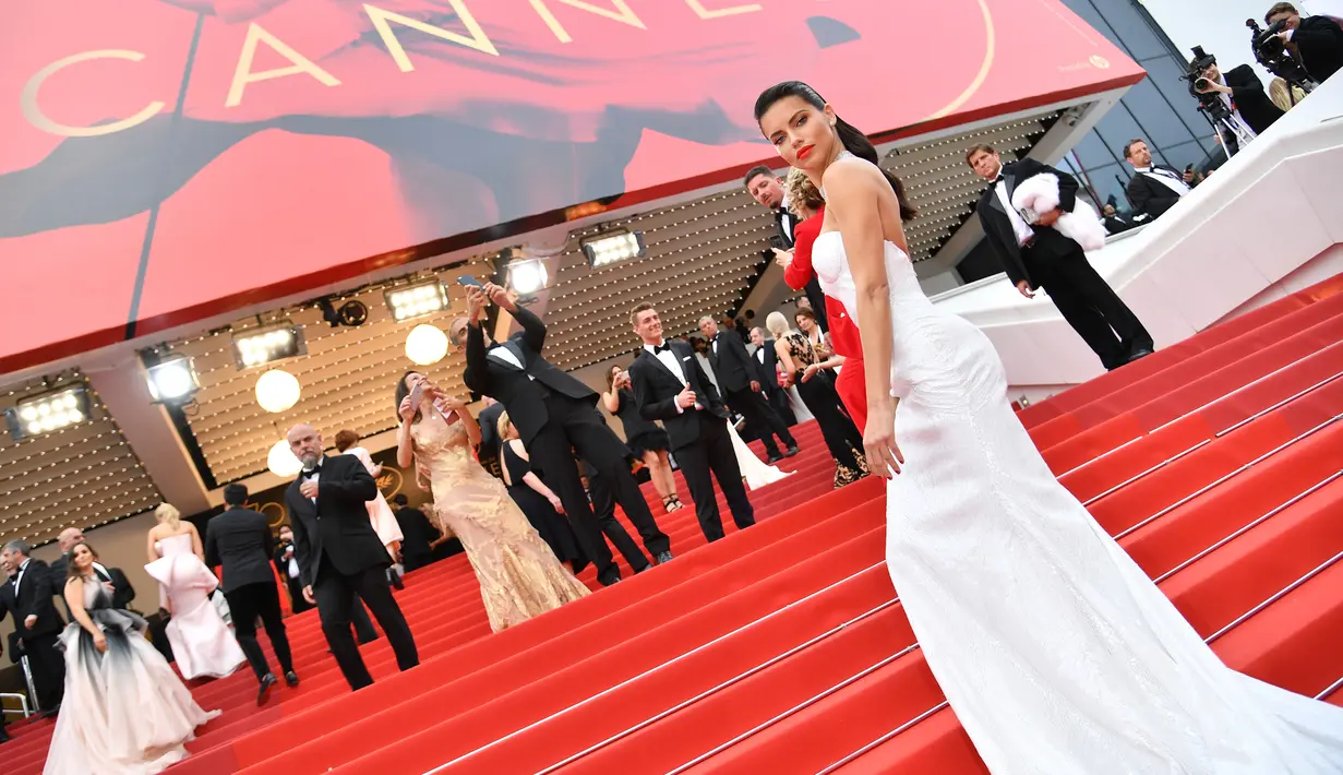 Model asal Brasil, Adriana Lima berpose saat tiba menghadiri pemutaran film 'Loveless' (Nelyubov) pada acara Festival Film Cannes ke-70, Prancis (18/5). Adriana Lima tampil cantik dan seksi mengenakan gaun berwarna putih. (AFP Photo/ Alberto Pizzoli)