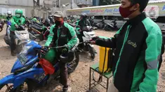 Pengemudi ojek online melakukan penyemprotan disinfektan sebelum mengangkut penumpang di Shelter Sudirman, Jakarta, Senin (8/6/2020). Pemprov DKI mulai mengizinkan ojek daring maupun konvensional mengangkut penumpang di PSBB transisi dengan menerapkan protokol kesehatan. (Liputan6.com/Angga Yuniar)